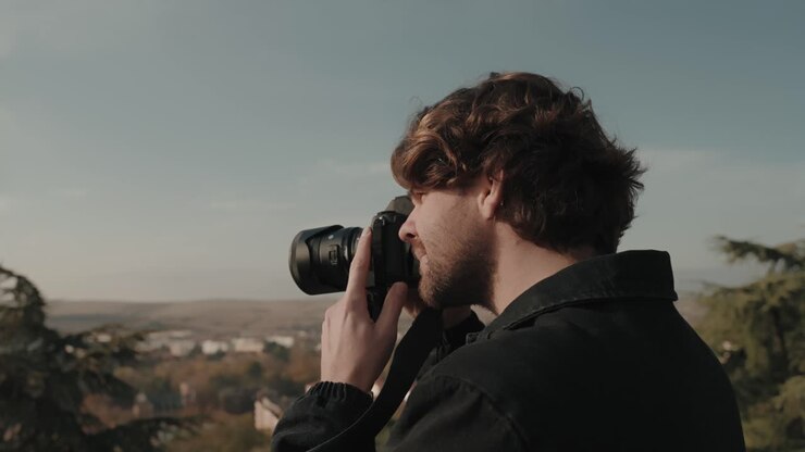 Young hipster photographer taking photo of scenery