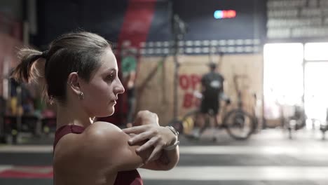 mujer estirándose en el gimnasio