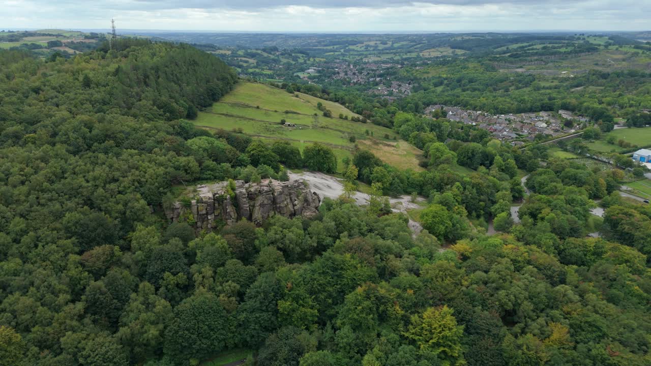Scenic aerial drone view of Bolehill mountain and hiking trail surrounded by rolling green landscapes in Derbyshire Dales England UK