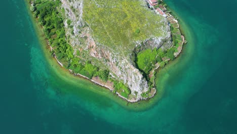 Península-Pedregosa-Rodeada-Por-Las-Aguas-Color-Esmeralda-Del-Antiguo-Lago-En-El-Pueblo-Turístico-De-Lin,-Pogradec