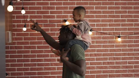 Positive-black-father-giving-a-ride-on-his-shoulder-to-carefree-playful-little-mixed-race-son