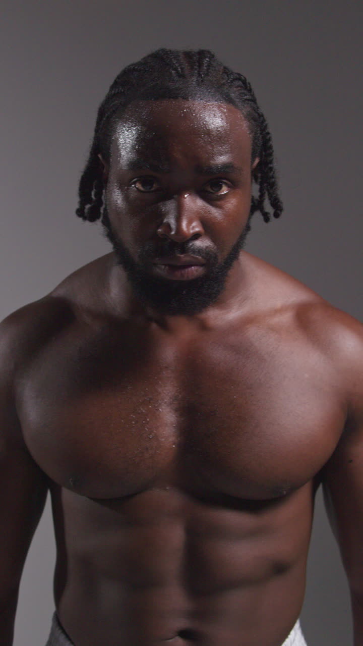 fotografía de estudio de cerca de un boxeador golpeando la cabeza con guantes antes de un partido de boxeo contra un fondo gris
