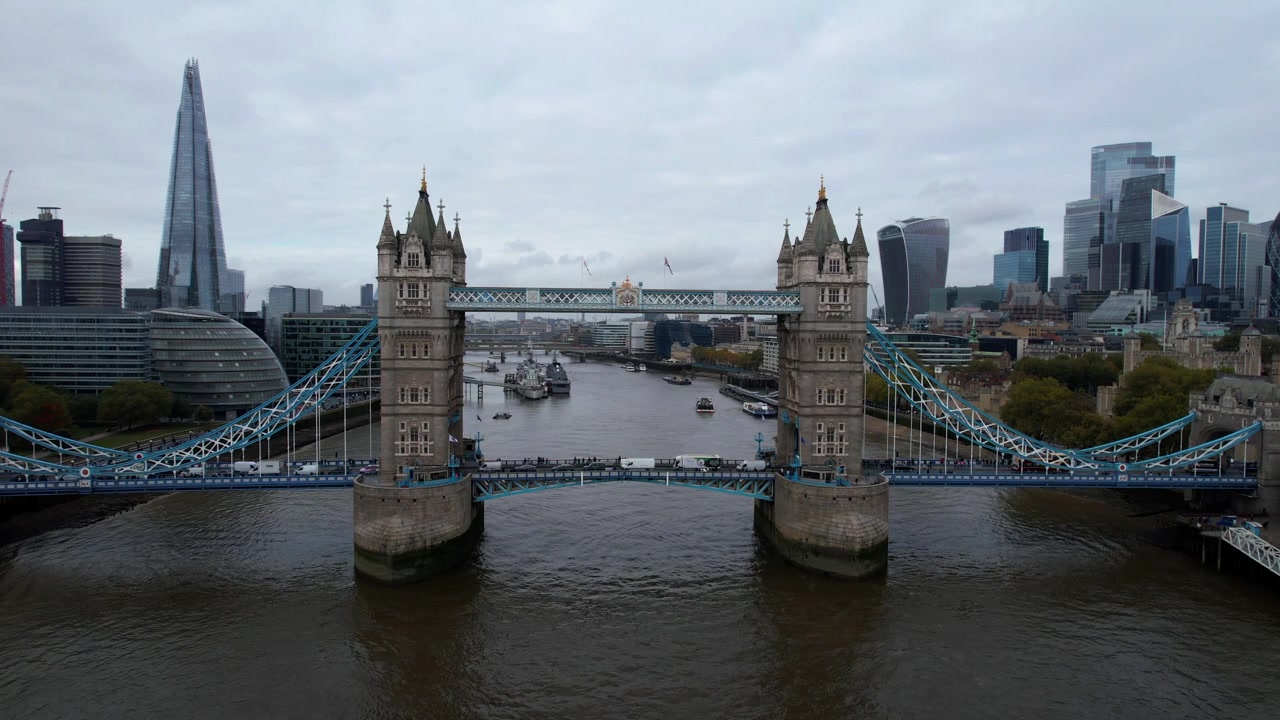 Tower Bridge over Themsen under trafikprop med London by i baggrunden på en overskyet dag. Luftfoto.