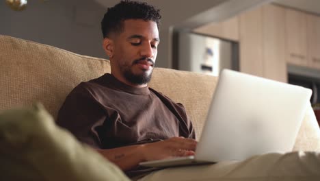Serious-ethnic-man-working-on-laptop-at-home
