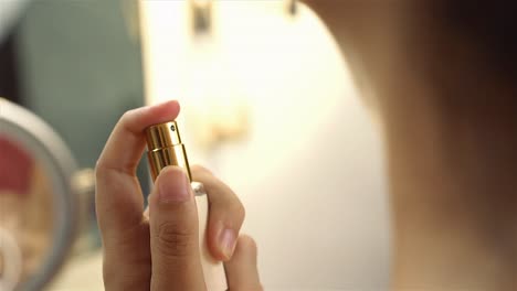 mujer rociando perfume en su cuello botella de belleza elegante primer plano