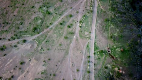 Vista-Aérea-De-Motocicletas-Que-Viajan-Por-Caminos-Sinuosos-Dentro-De-La-Reserva-Natural-Del-Lago-Magadi-En-Kenia,-áfrica-Oriental
