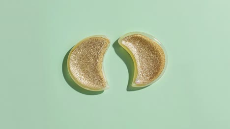 gold glitter eye patches on a mint green background