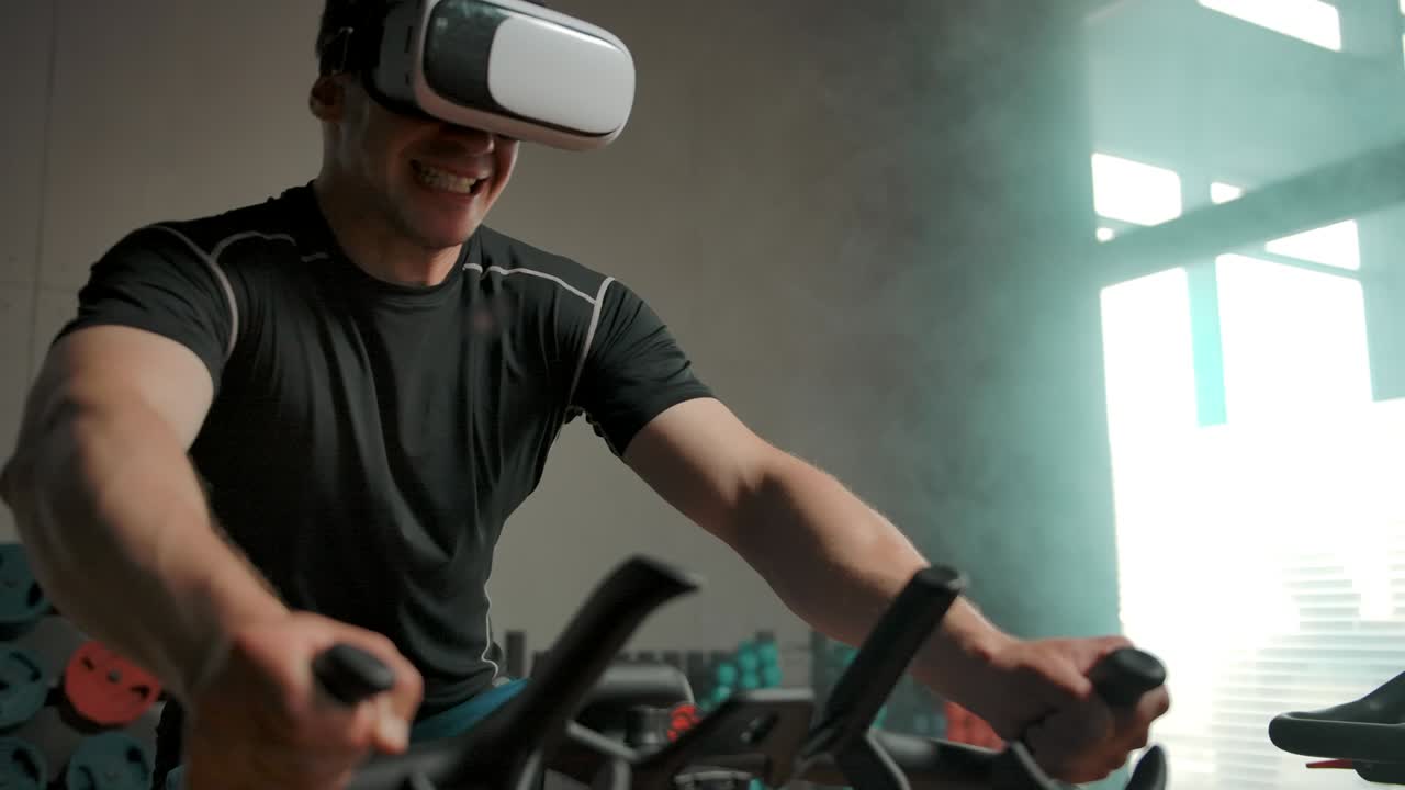 A man performs a heavy exercise on a bicycle simulator in a VR helmet