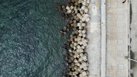 birdseye view of shoreline with erosion control concrete blocks, stairs enter to ocean