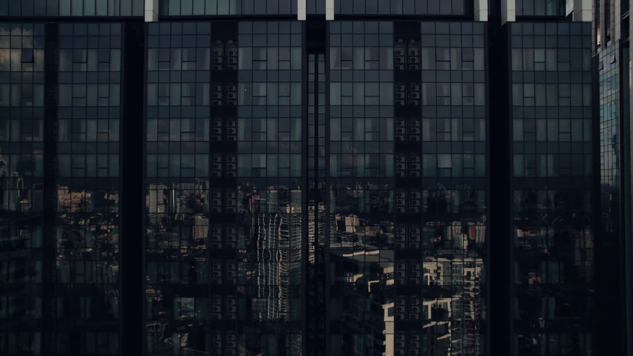 Skyline building glass wall facade reflecting city highrise buildings, KLCC skylines, Kuala Lumpur, Aerial closeup