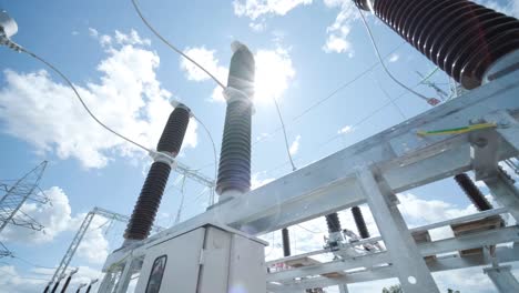 many high voltage electrical insulators in power substation against blue sky background