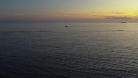 barcos navegando durante una increíble puesta de sol, dirigiéndose al sol, toma aérea