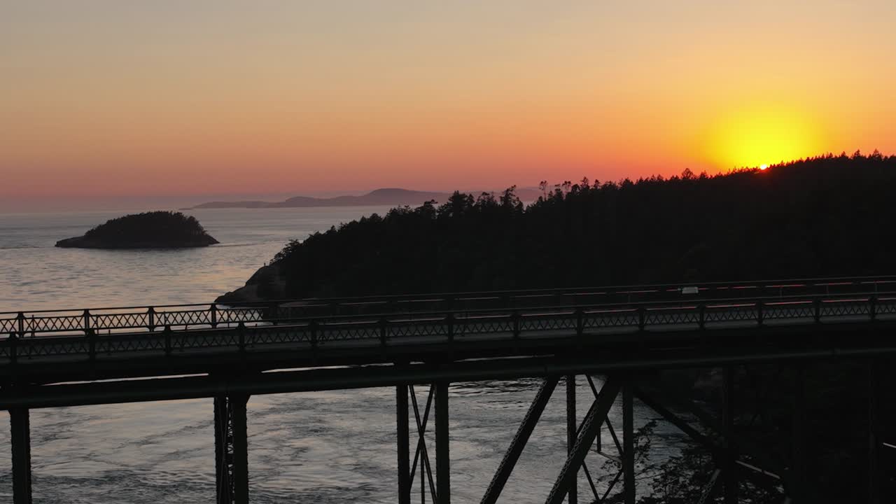기만 패스 주립 공원을 가로질러 운전하는 자동차의 천천히 움직이는 공중 샷과 배경에서 일몰의 빛