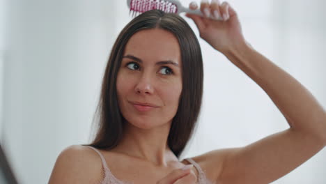 Señora-Satisfecha-Cepillándose-El-Cabello-En-El-Primer-Plano-Del-Baño.-Mujer-Disfrutando-De-Una-Rutina-De-Belleza