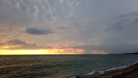 timelapse of a glowy magical orange sunset at the beach, sea