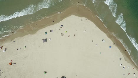 Vista-Panorámica-De-Mirar-Hacia-Abajo-En-Una-Playa-Con-Turistas-Que-Se-Distancian-Socialmente-Mientras-Están-De-Vacaciones