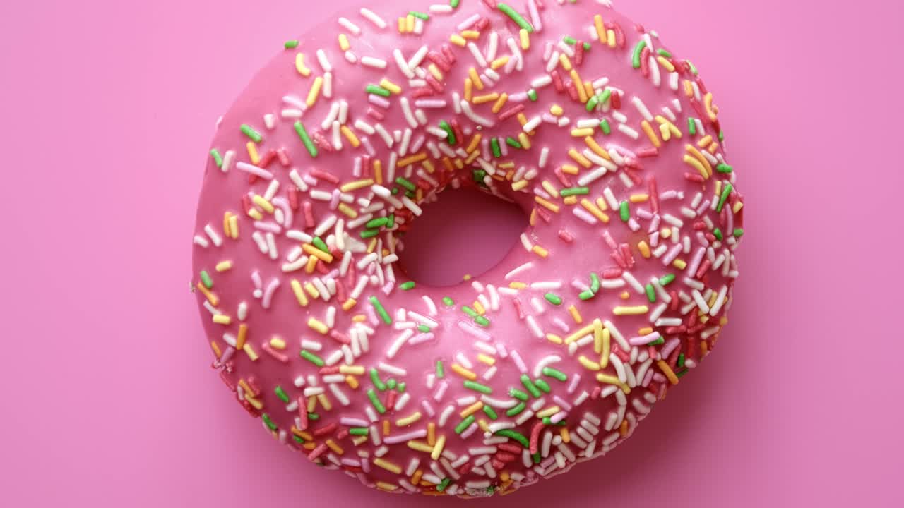Rosquinha carmesim giratória apetitosa em close-up com cobertura de confeitaria isolada. Câmera 4k Dragon RED