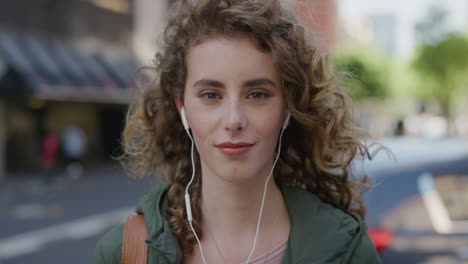 portrait of attractive young woman smiling calm looking at camera enjoying listening to music wearing earphones in city street beautiful caucasian female urban lifestyle