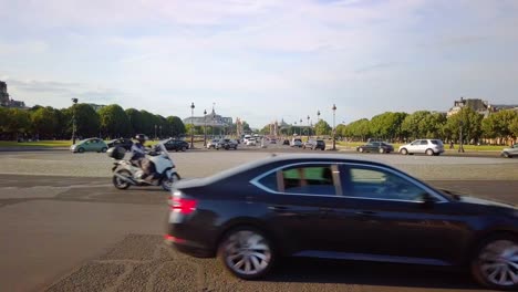 still shot of cars circling large roundabout along avenue de tourville in paris