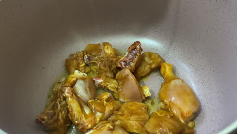 oil being poured in cooking pot over chicken pieces