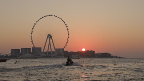 unsurpassed sunset over the biggest ferris wheel in dubai marina uae.