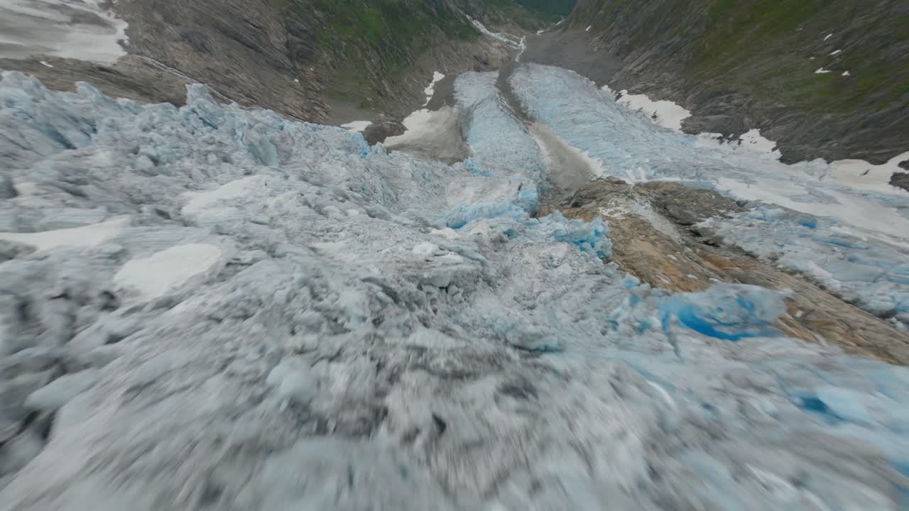 vuelo dinámico fpv sobre el derretimiento del hielo glaciar en las montañas noruegas - buarbreen, noruega
