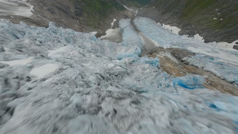 dynamic fpv flight over melting glacier ice in norwegian mountains - buarbreen,norway