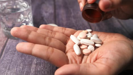 hand taking pills with water