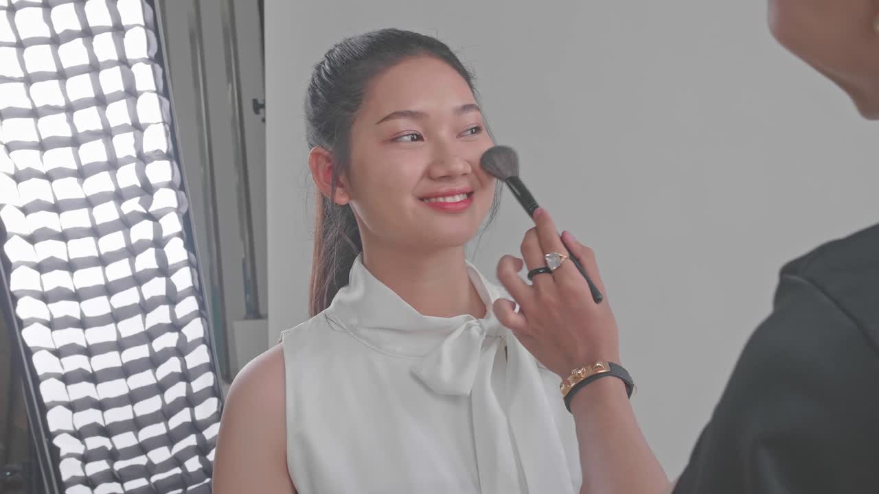 Makeup Artist Applying Makeup to a Young Woman