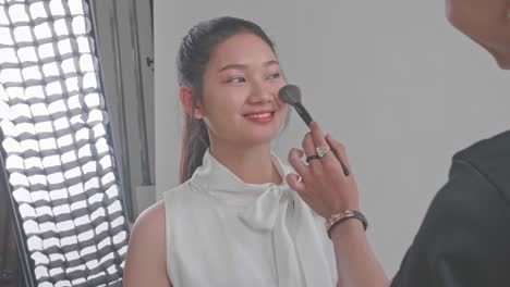 makeup artist applying makeup to a young woman