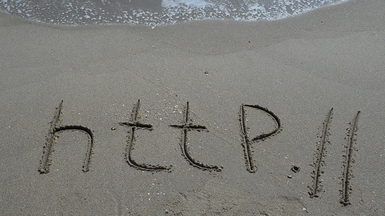 The word http handwritten in sand on a beach. Shooting on the beach