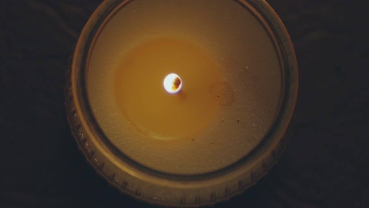 Candela rustica profumata accesa in una stanza buia