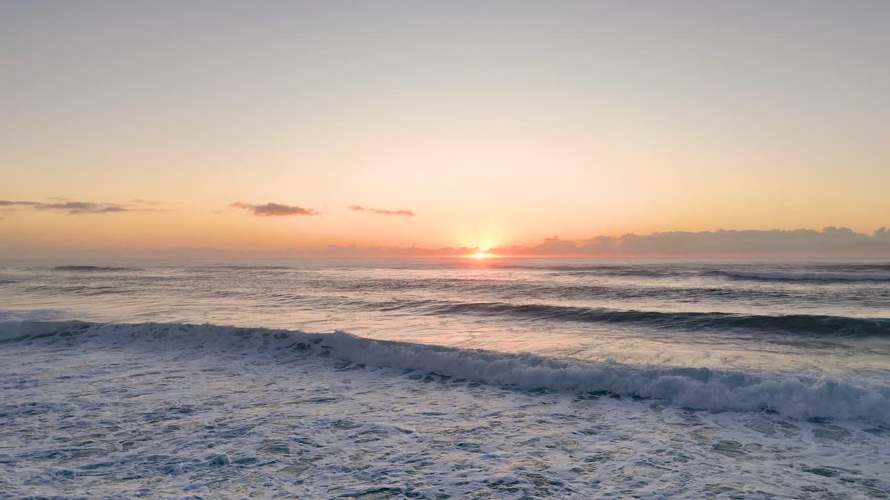 Sunrise over ocean waves with serene atmosphere