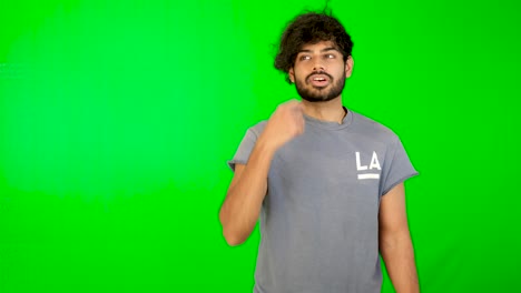 guy talking in front of camera with green screen and green background
