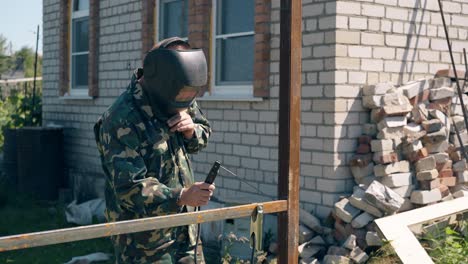 Handwerker-Mit-Maske-Schweißt-Am-Tag-Teile-Des-Kreishauszauns