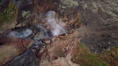 cloudy steams in geothermal area near reykjadalur in south iceland, aerial orbit