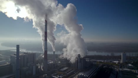 Aerial-orbit-shot-of-the-big-coal-powered-powerplant-generating-a-lot-of-smoke