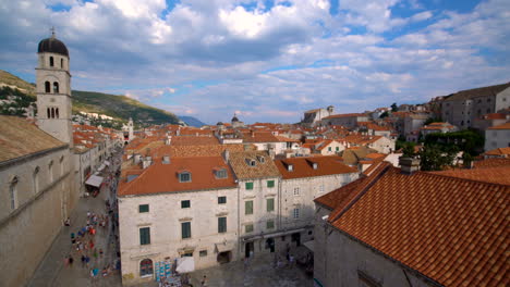 mujer caminando por el muro de la ciudad vieja de dubrovnik, croacia