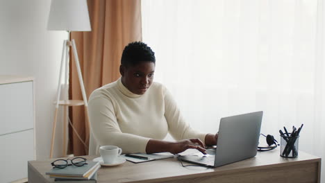 mujer trabajando desde casa en una computadora portátil