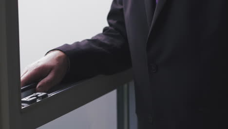 businessman walks to open window in modern company office