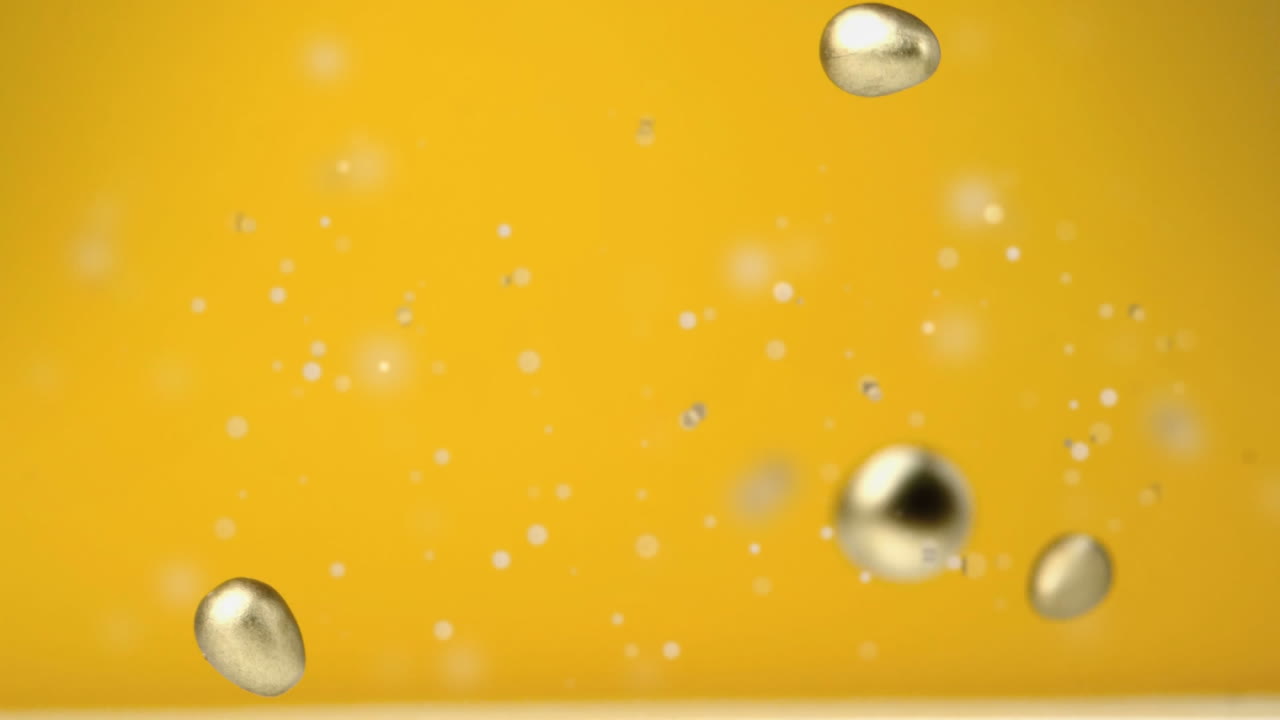 네 개의 초콜릿 골든 이스터 계란이 떨어지고 노란색 배경에  ⁇ 페티가 날아다니는 애니메이션