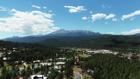 majestic aerial fight toward pikes peak, outskirts of suburban colorado springs below