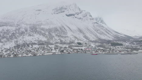 kåfjord town centre and harbour at the foot of a snowy mountain in olderdalen, norway