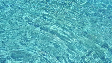 Agua-Azul-Cristalina-De-Una-Piscina-Con-Ondas-Lentas-En-Su-Superficie