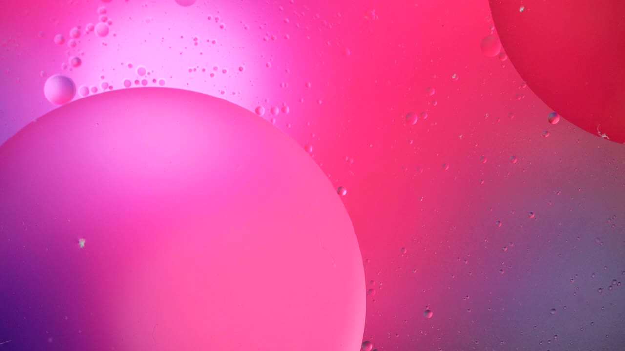 Fantastic structure of colorful bubbles. Chaotic motion. Abstract colorful paint. Top view. Movement of bubbles in the liquid. Oil surface multicolored background. Macro