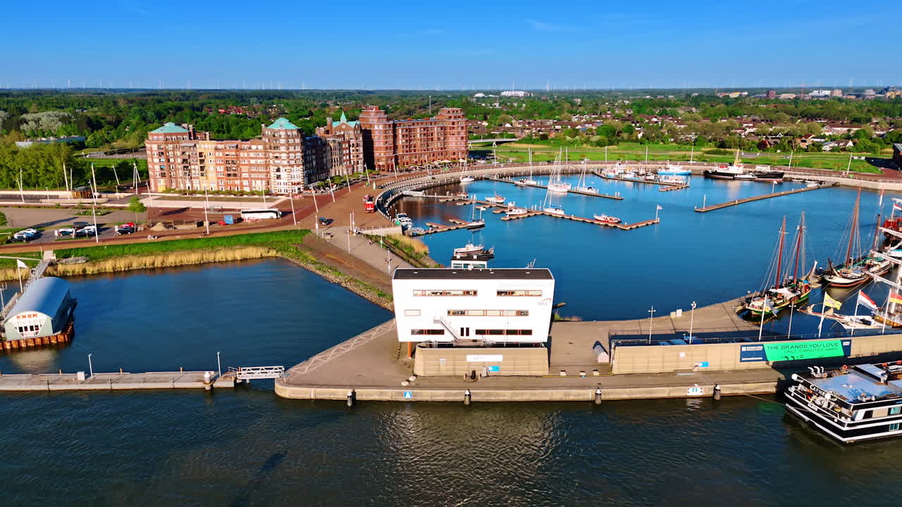 Port on the city of Lelystad, the Netherlands on Lake Markemeer. Beautiful buildings on the waterfront and lush greenery of the city at backdrop.
