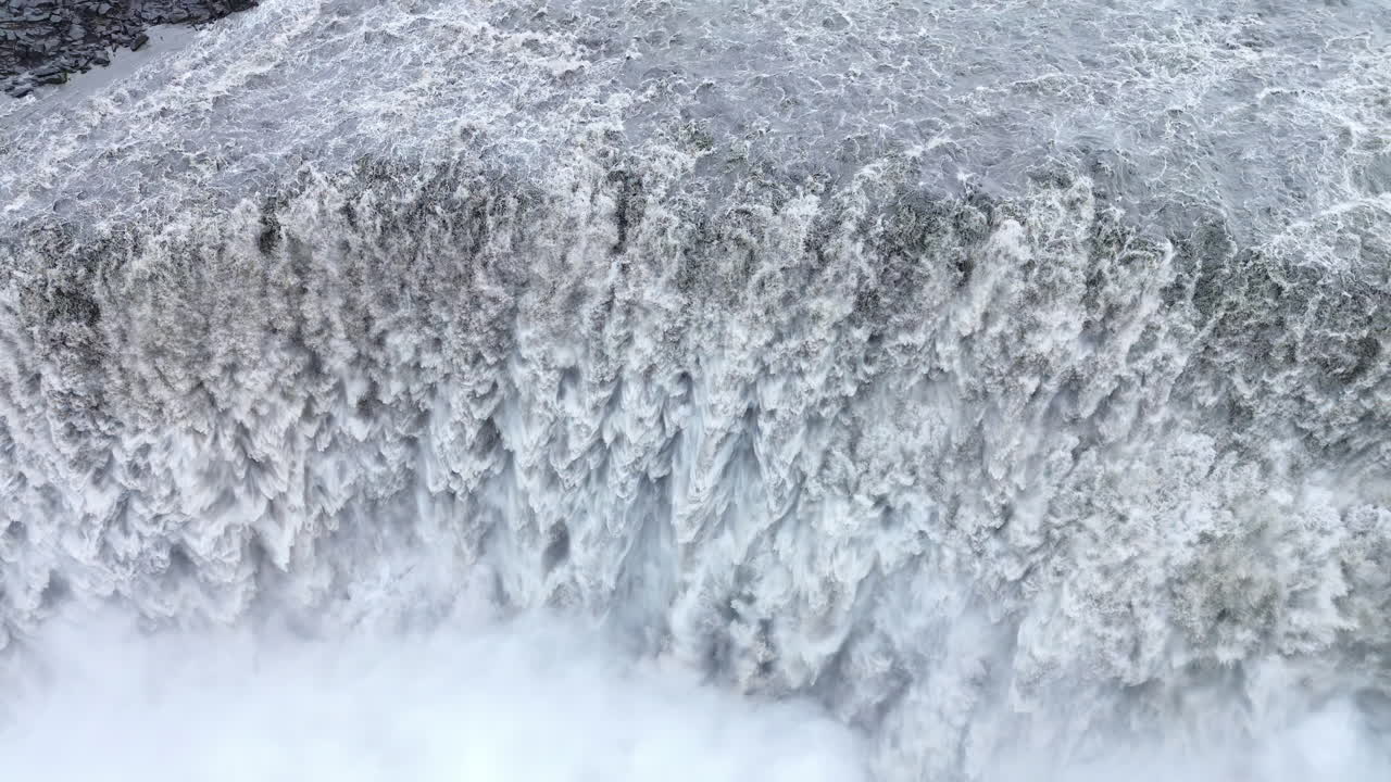 Aerial drone view of Dettifoss waterfall in Vatnajokull National Park, Northeast Iceland. Europe's most powerful waterfall crashes into a mist filled canyon with roaring white water and dramatic volcanic rock cliffs