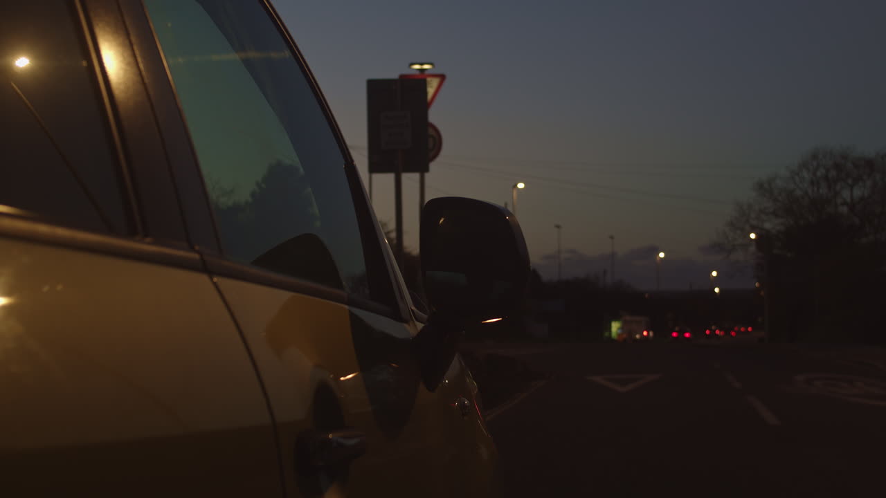 боковое зеркало выдвигается перед тем, как таинственная фигура входит в припаркованный автомобиль ночью