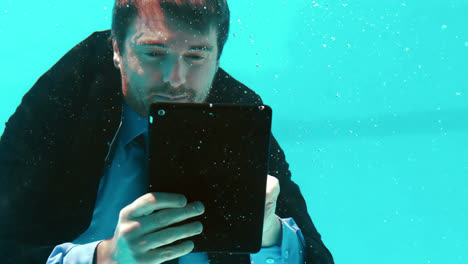 Businessman-using-his-tablet-underwater