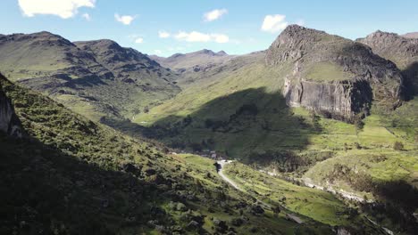 Drone-shot-in-between-huge-green-rocky-mountains-in-a-valley-located-in-the-highlands-of-Peru